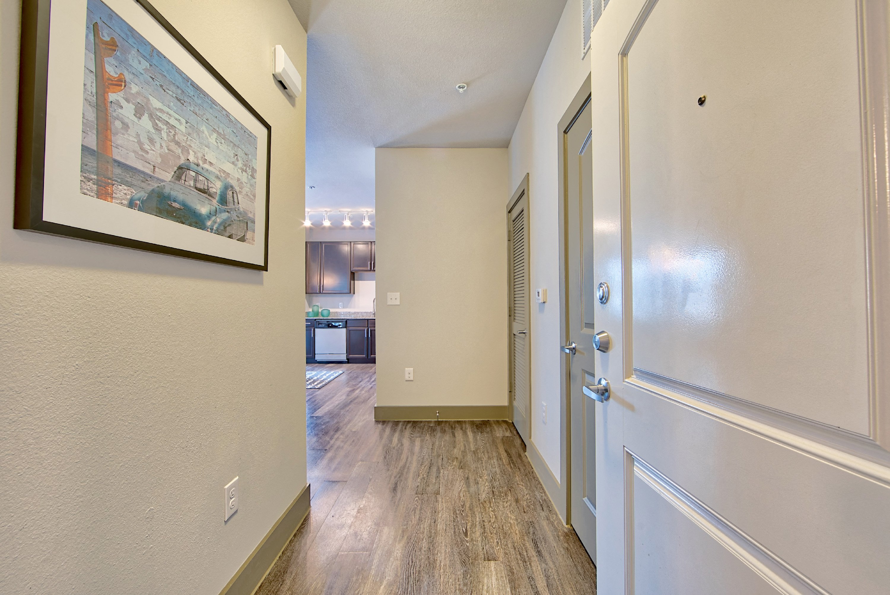 a hallway with a door to a kitchen and living room