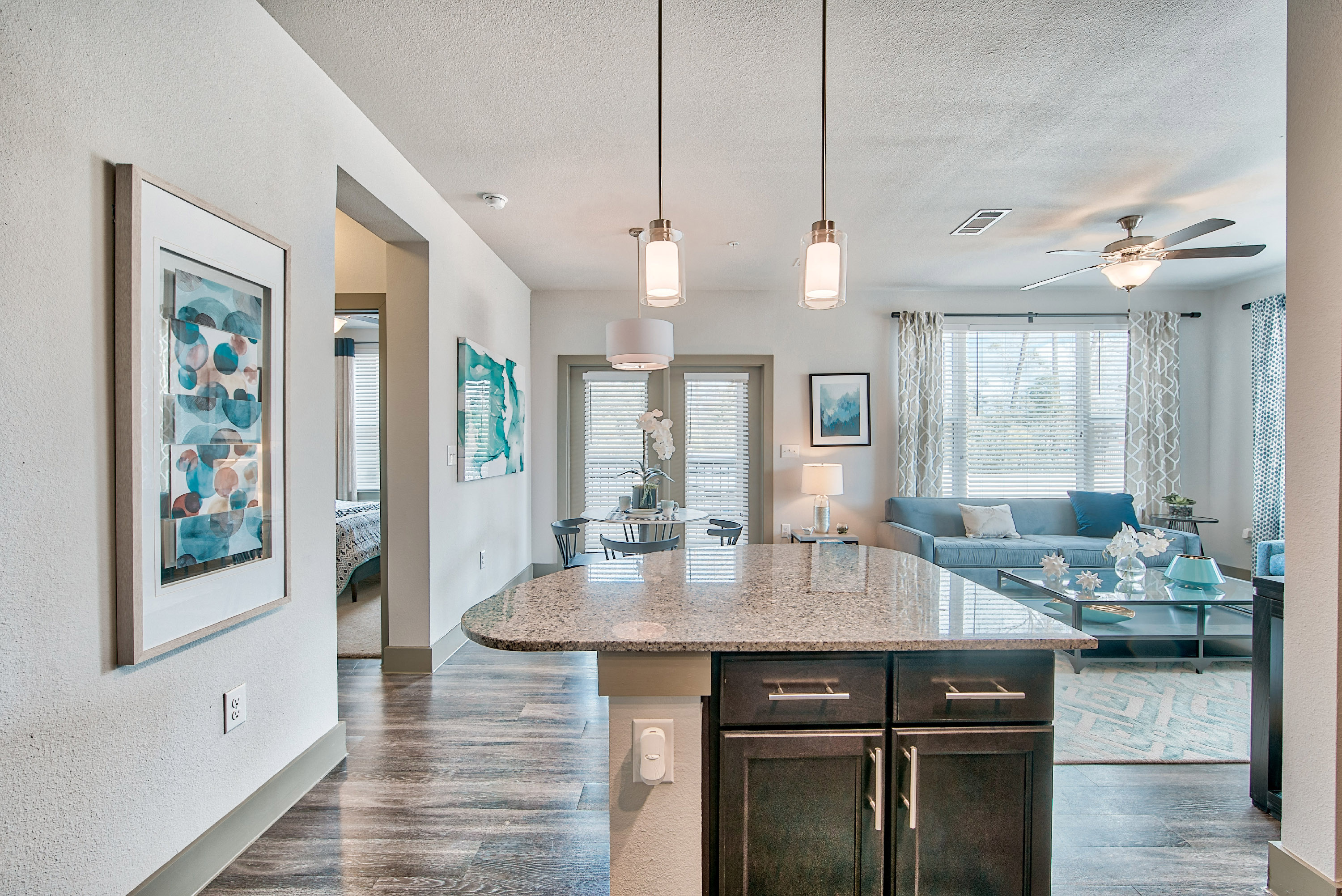 an open kitchen and living room with a ceiling fan