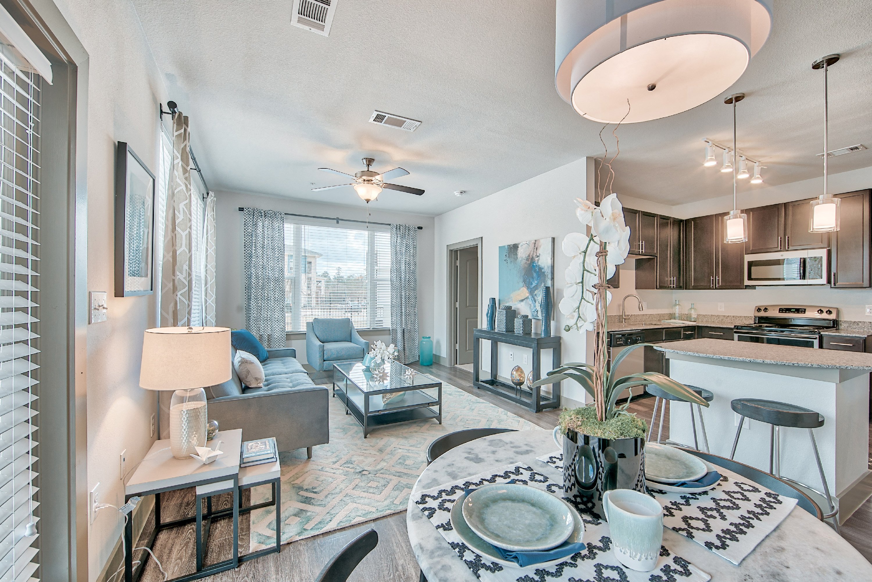 a living room and kitchen with a dining room table and chairs