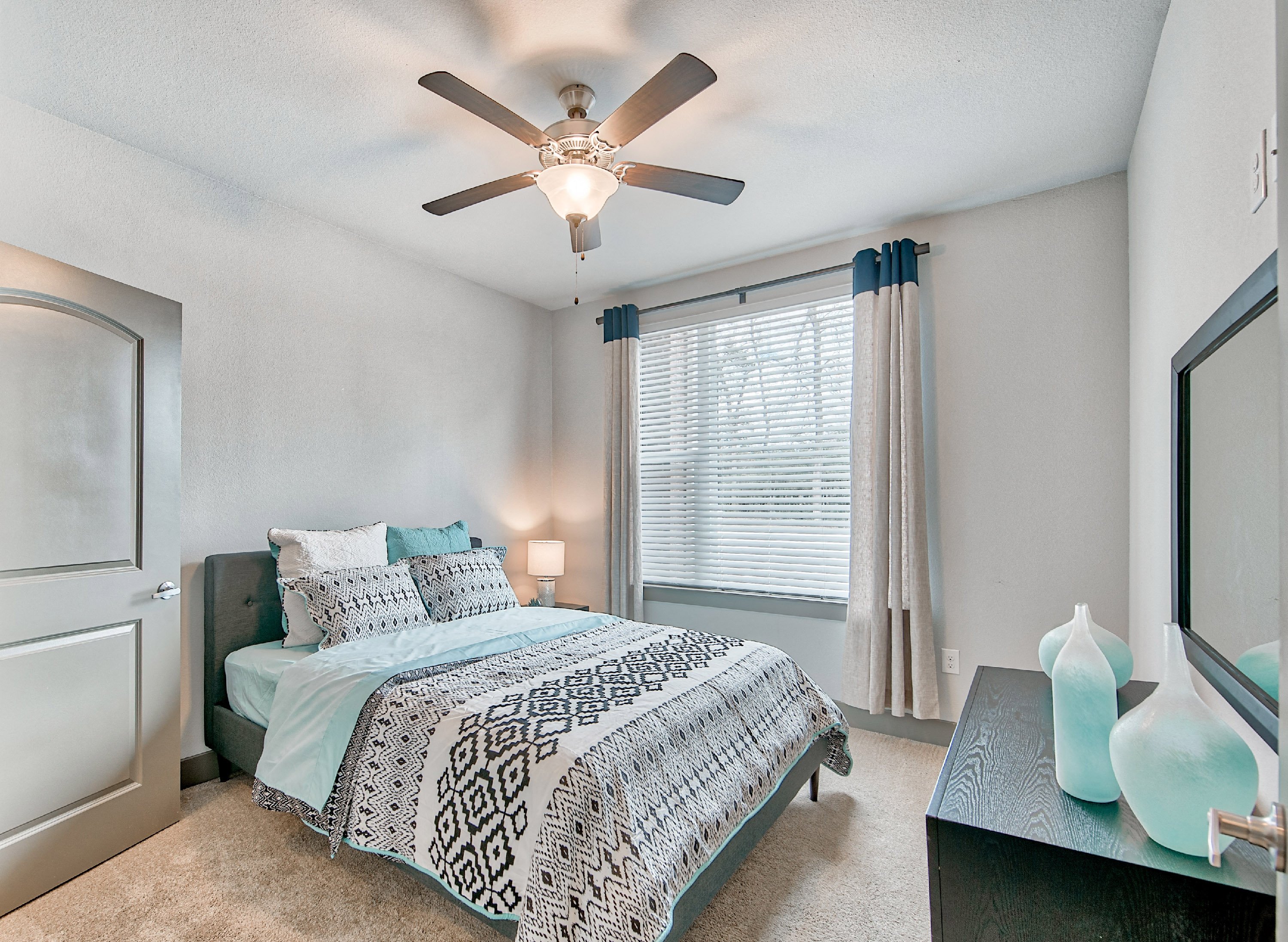 a bedroom with a bed and a ceiling fan