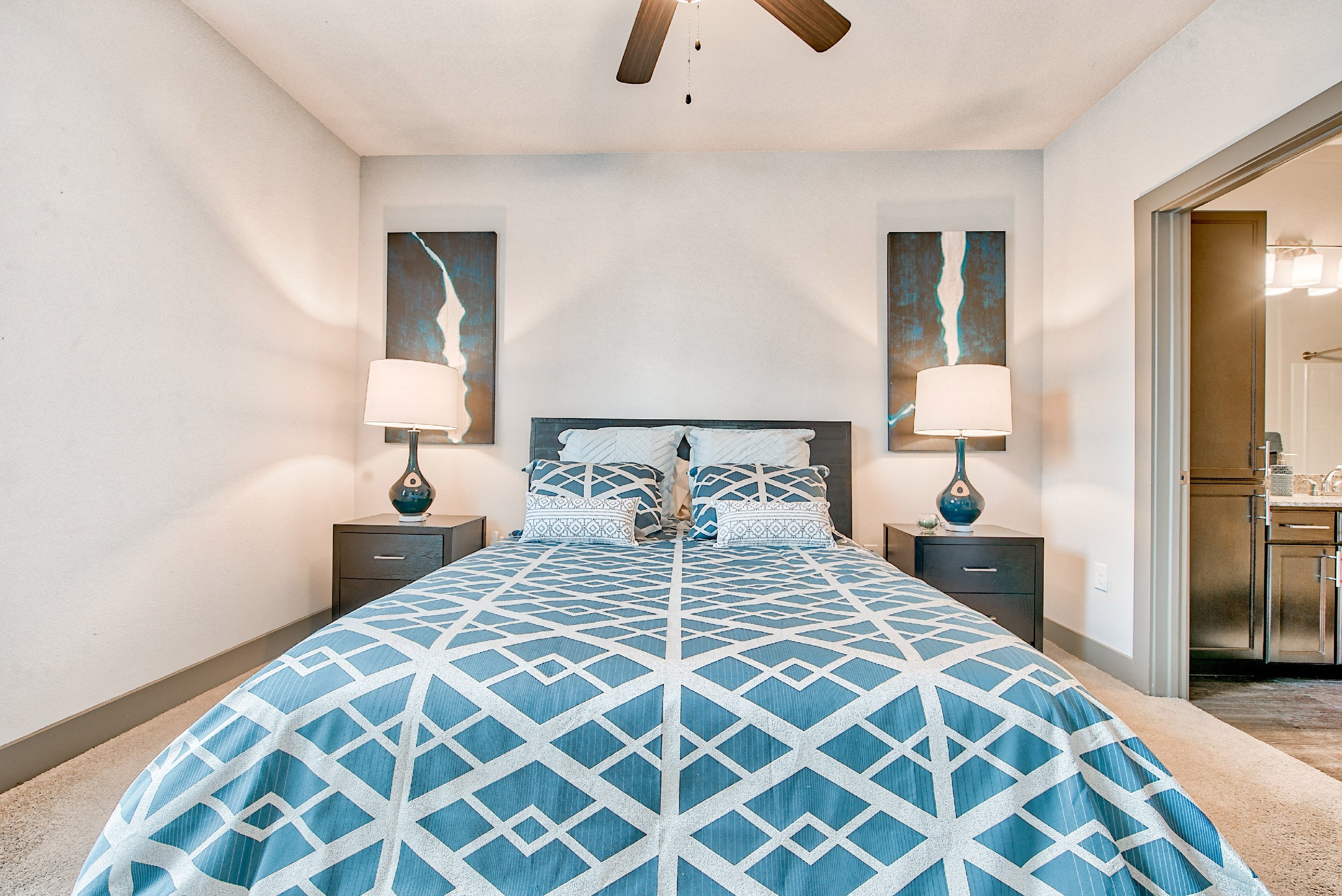 a bedroom with a large bed and a ceiling fan