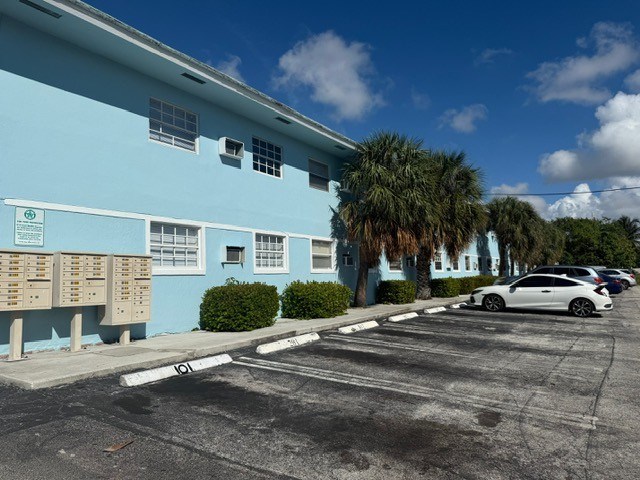 A blue building with a white car parked in front.