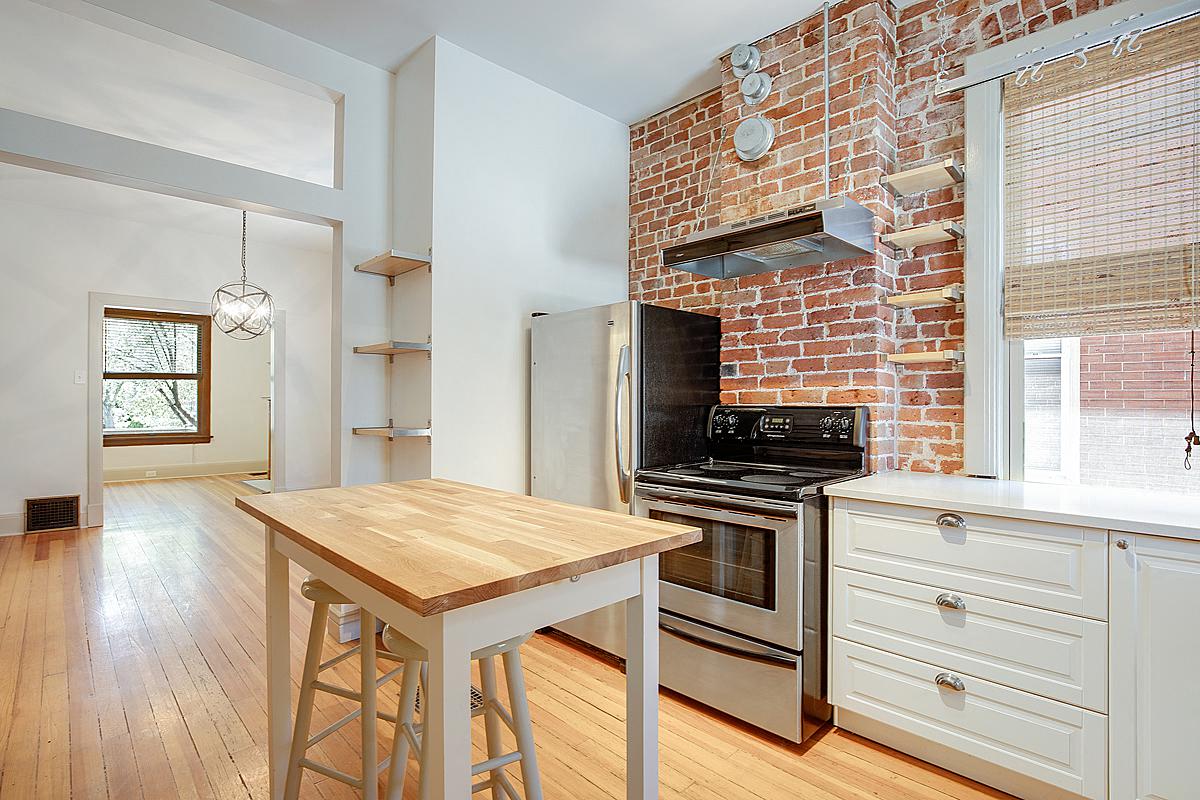 a kitchen with a brick oven and a wooden table