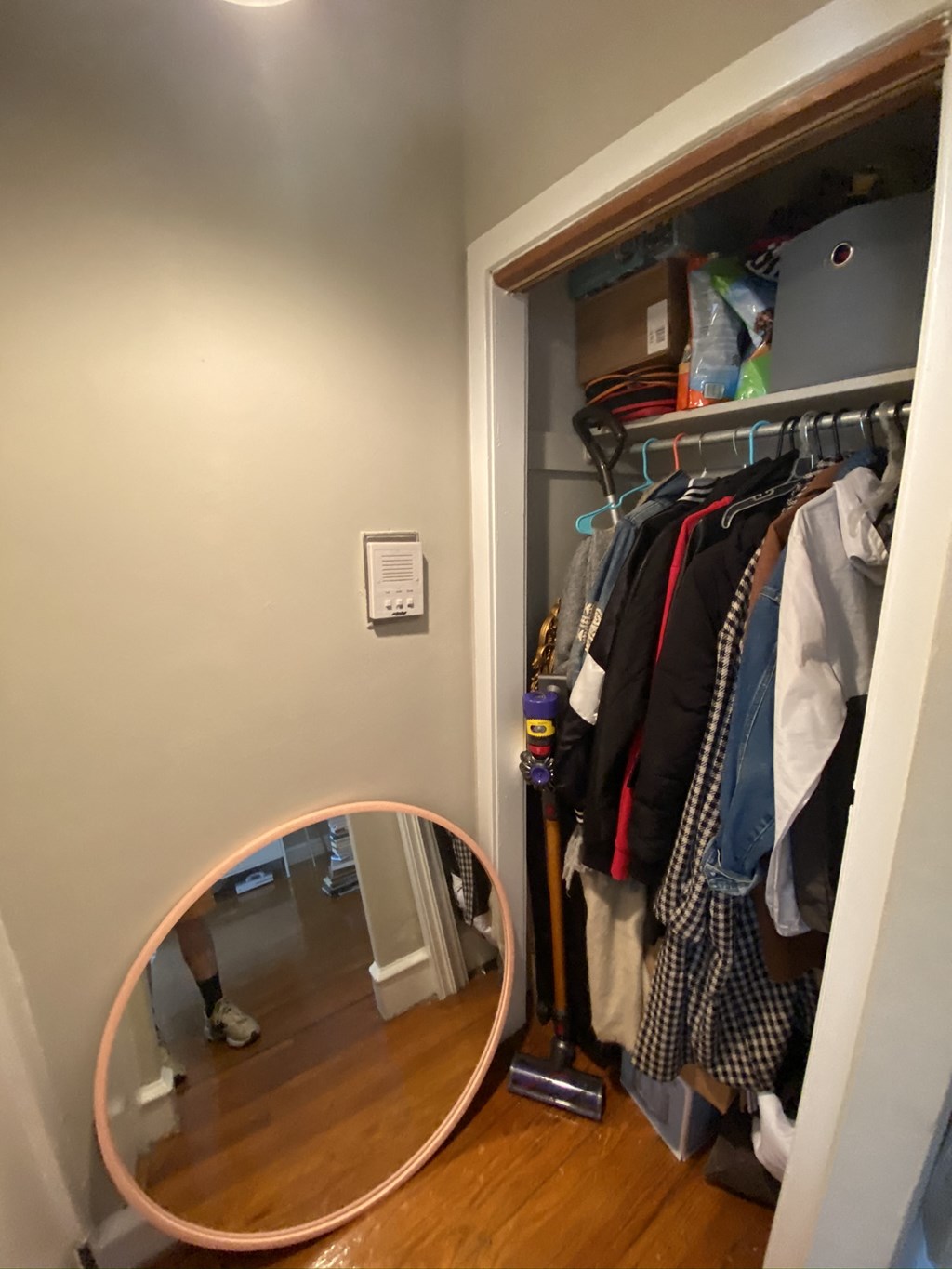 a closet with a mirror and a rack of clothes