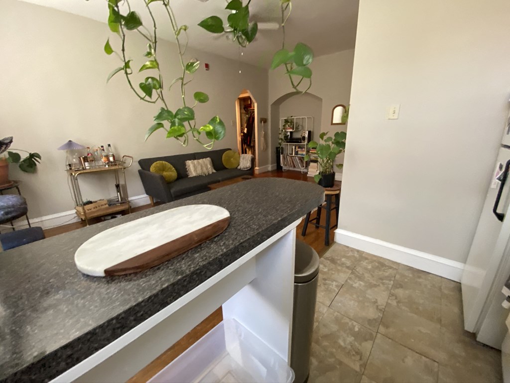 a kitchen with a counter top and a living room with a couch