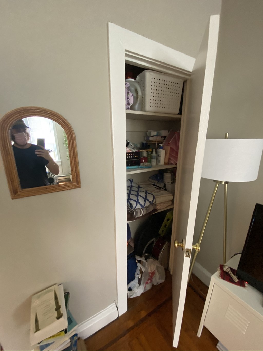 the door to the closet is open and a person is taking a picture of themselves