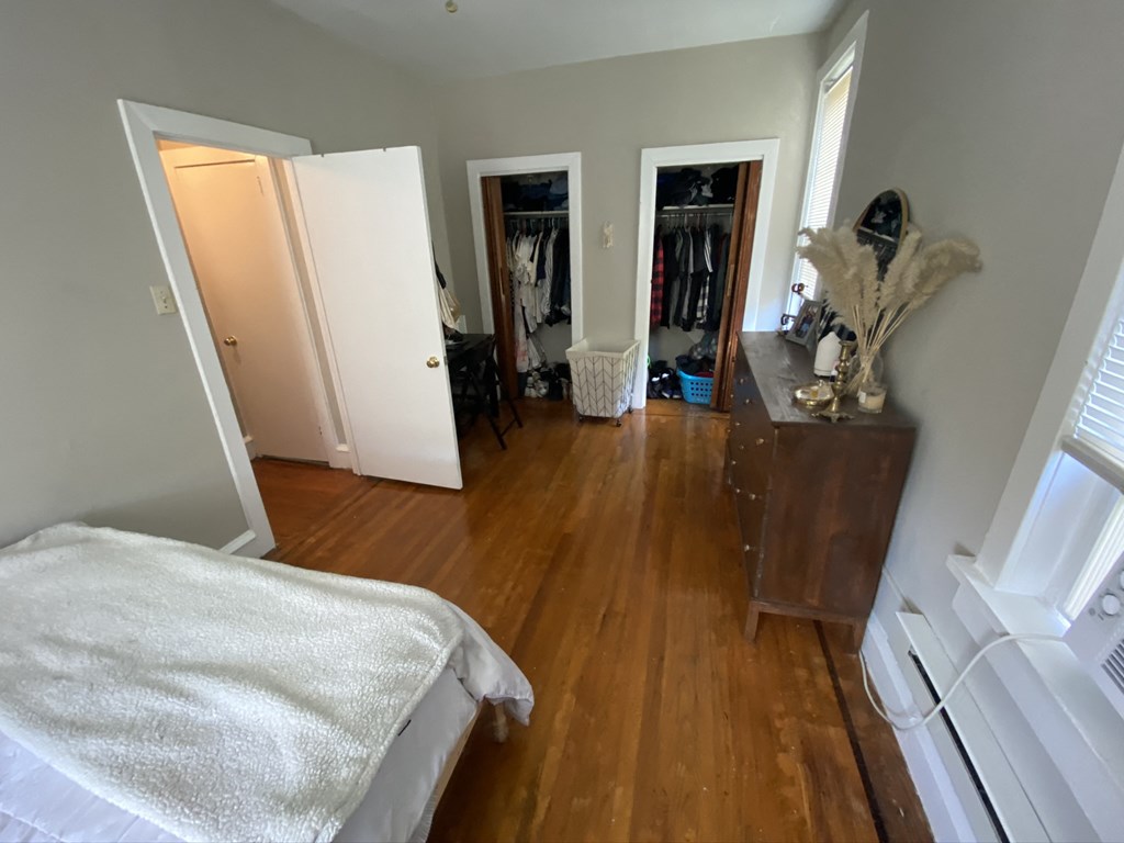 a bedroom with a bed and a dresser and a closet