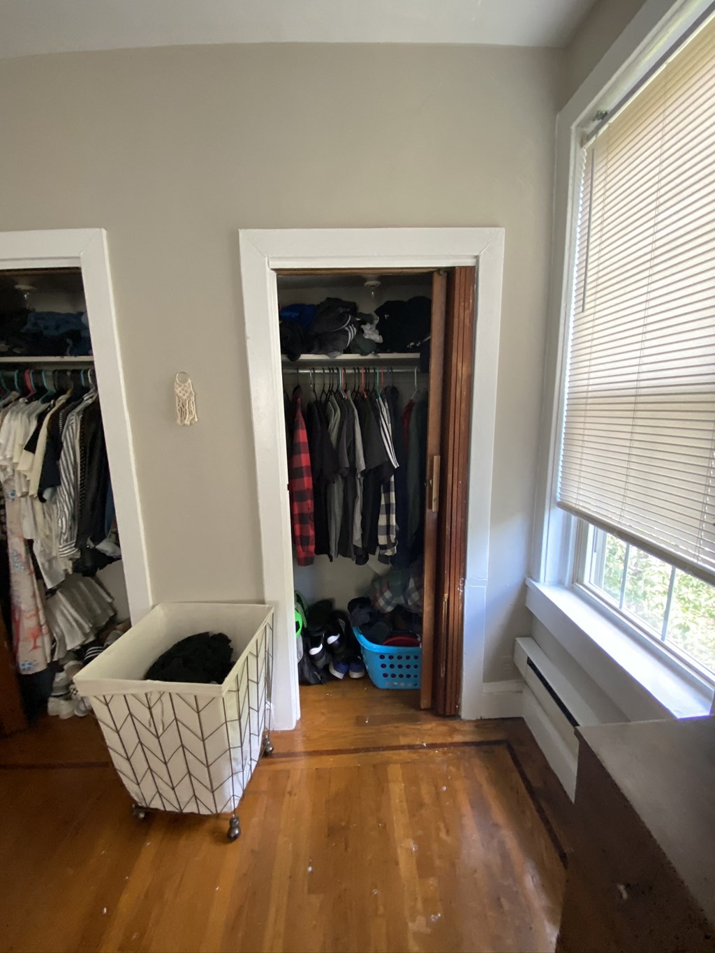 a room with a closet and a clothes rack and a window