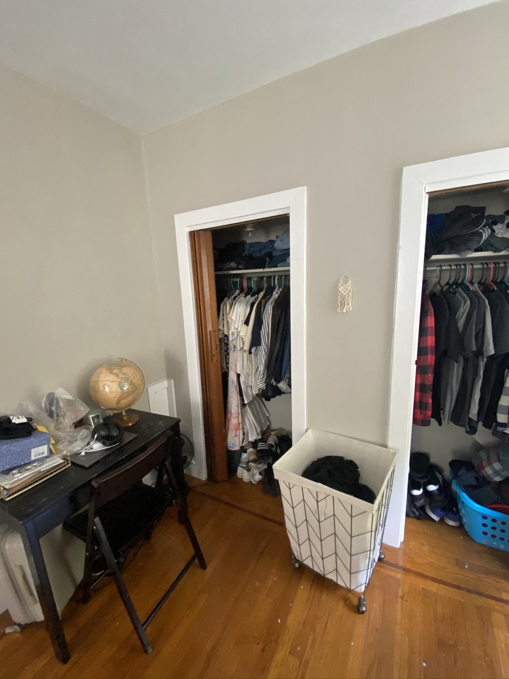a room with a closet with a clothes rack and a door to a closet