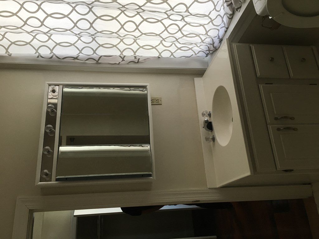 a small bathroom with a mirror and a window