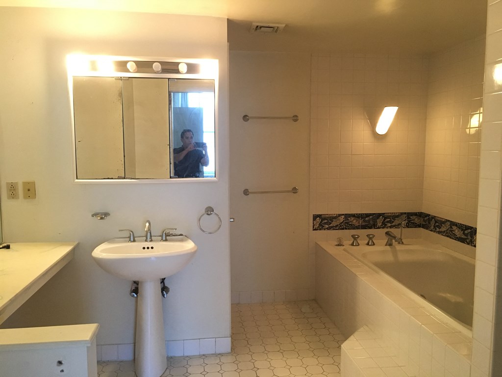 a bathroom with a sink and a mirror and a tub