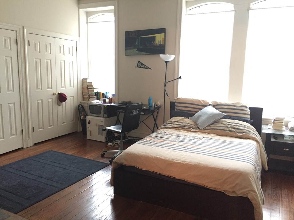 a bedroom with a bed and a desk with a computer