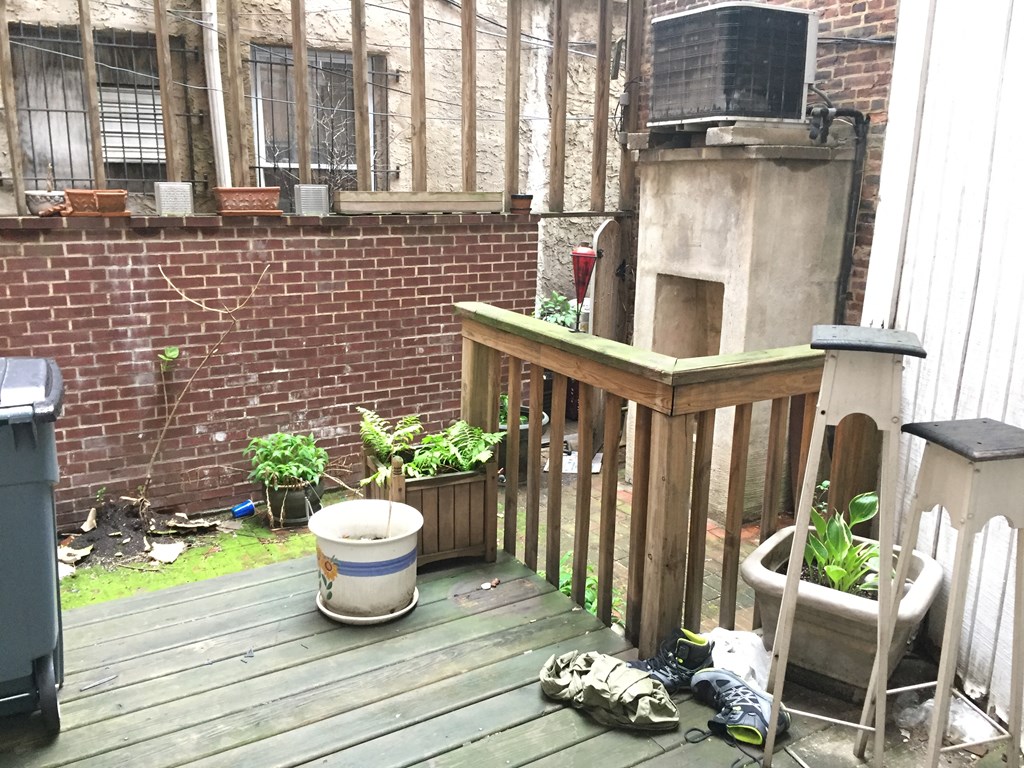 a backyard with a wooden deck and a brick building