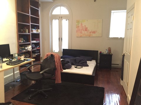 a bedroom with a bed and a desk and a window