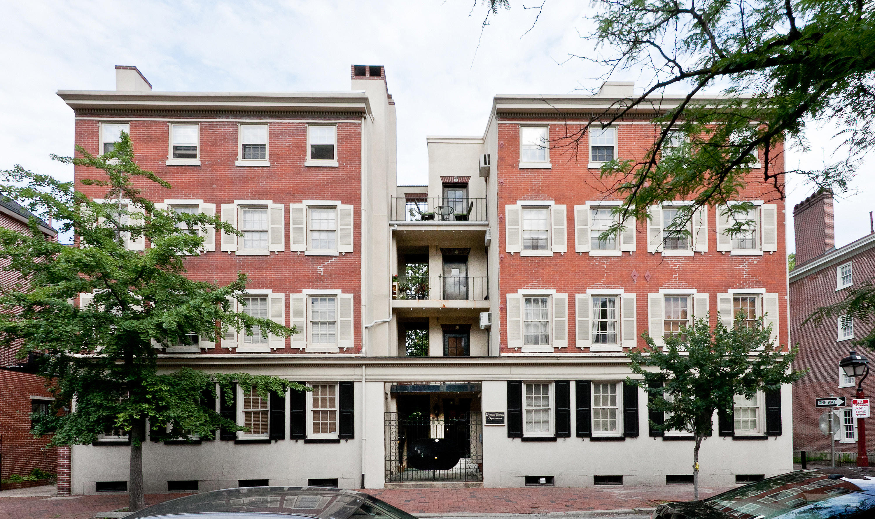 the exterior of a three story red brick apartment building