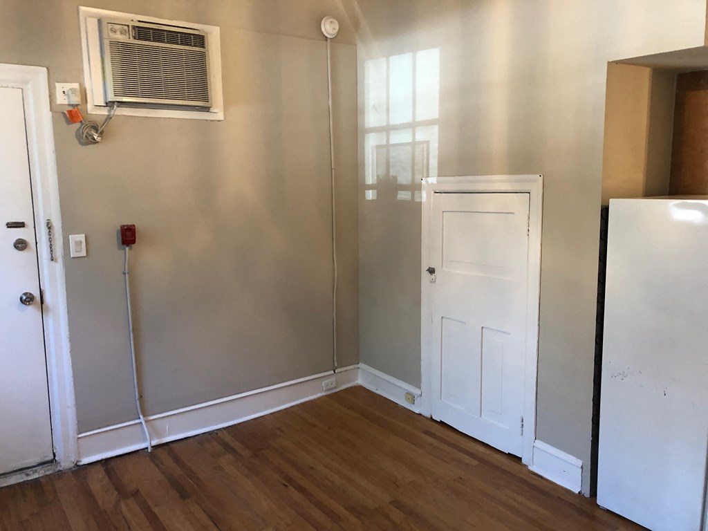 a small room with a refrigerator and a door