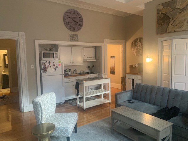 a living room with a couch a table and a kitchen