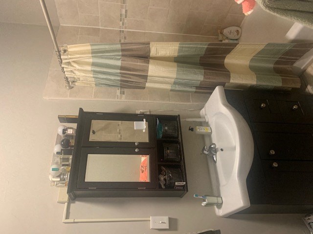 a bathroom with a urinal and a sink and a bed