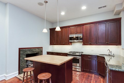 a kitchen with wooden cabinets and an island with three stools