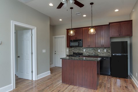 a kitchen with a island and a black refrigerator