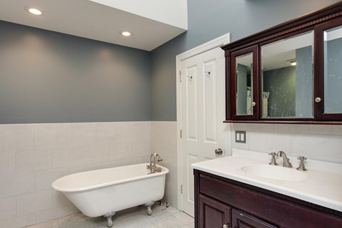 a bathroom with a tub and a sink and a mirror