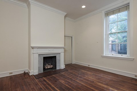 a living room with a fireplace and wooden floors