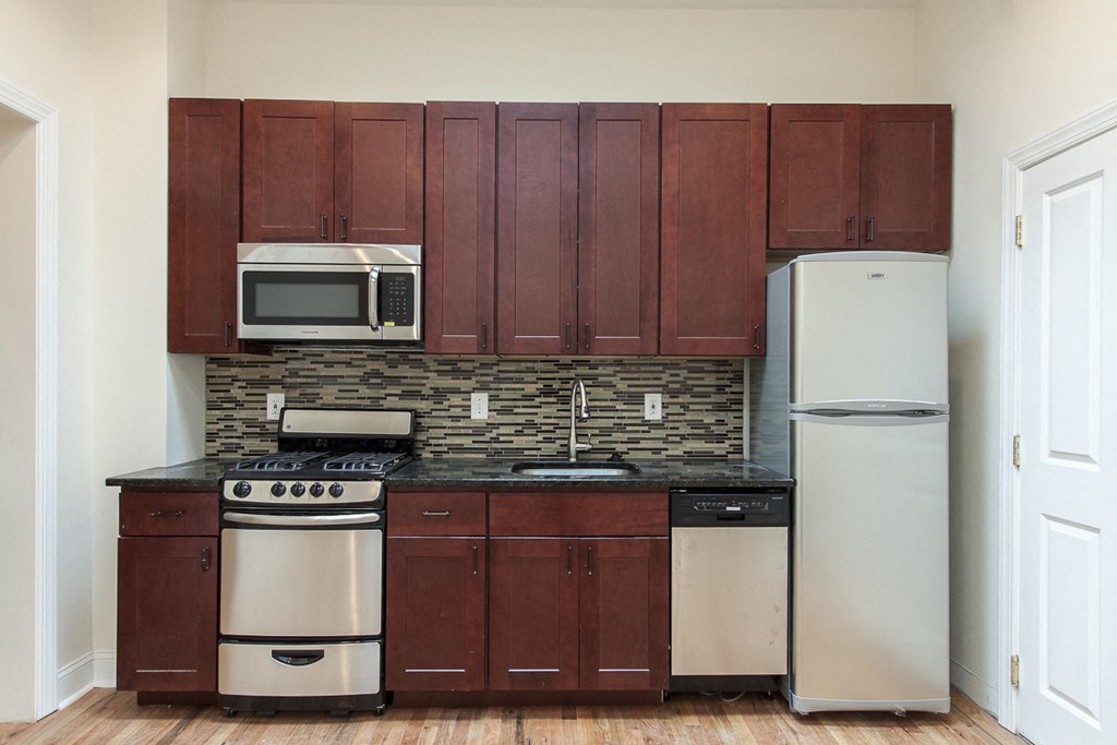 a small kitchen with a stove refrigerator and microwave