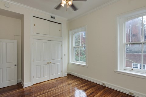 an empty room with two doors and a ceiling fan
