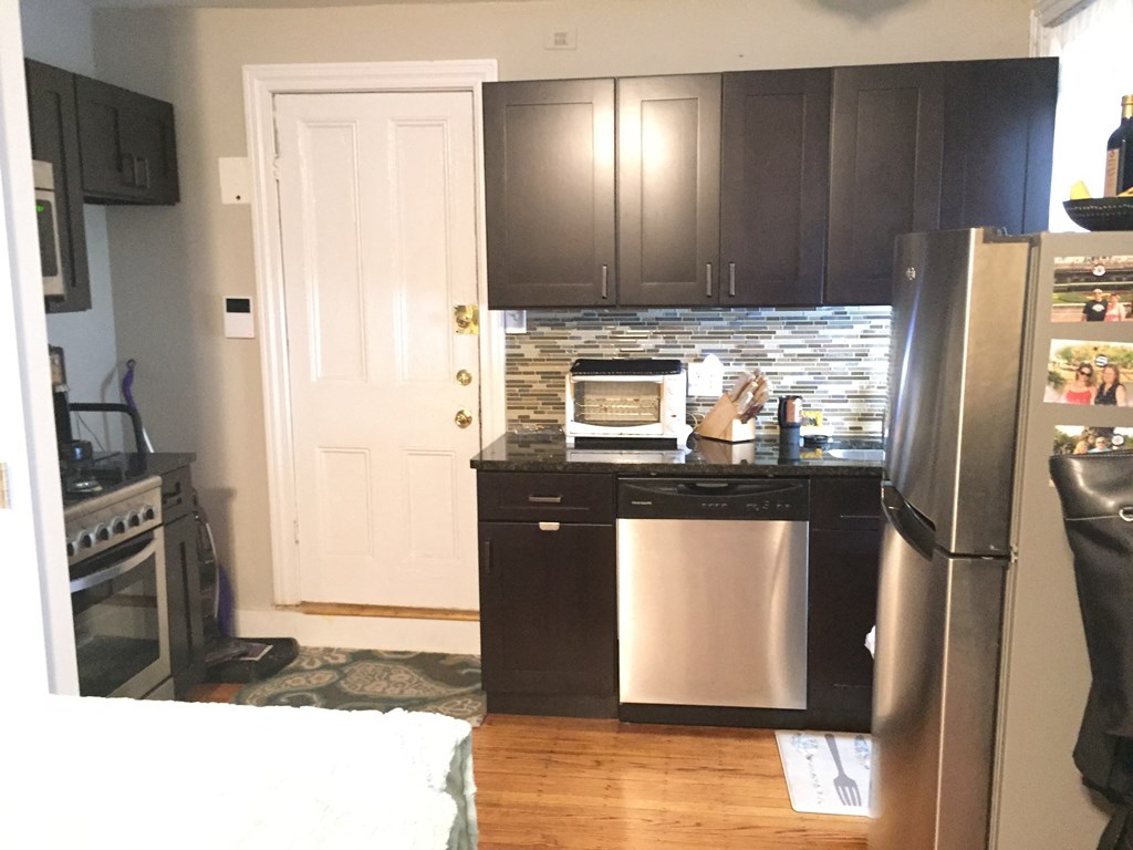 a small kitchen with stainless steel appliances and black cabinets
