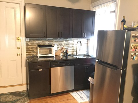 a small kitchen with stainless steel appliances and black cabinets