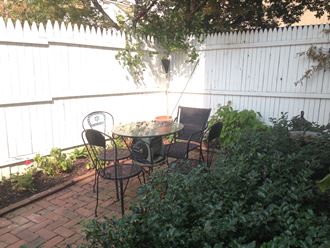 a patio with a table and chairs in a backyard