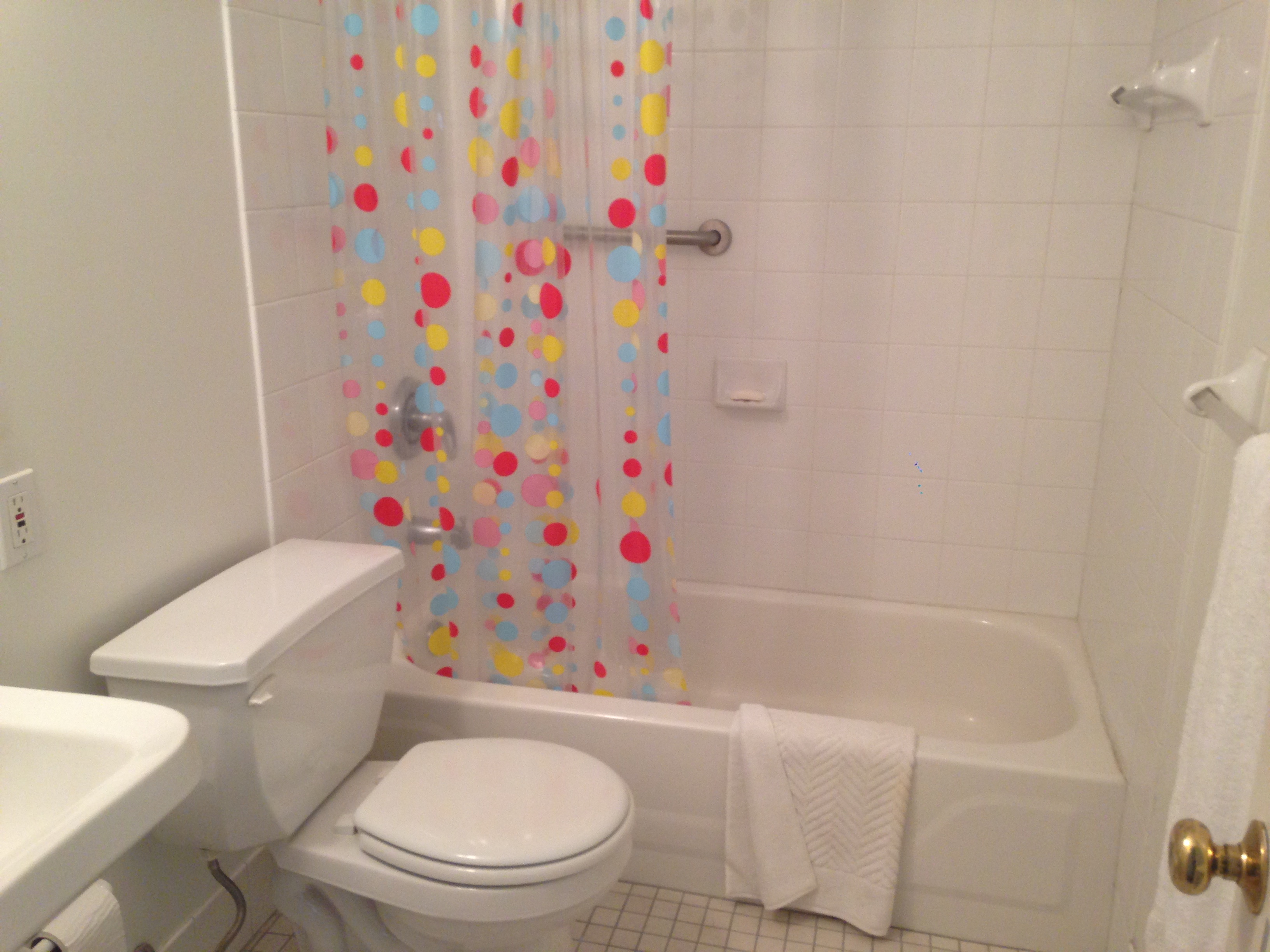 a white bathroom with a shower curtain and a toilet
