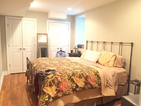 a bedroom with a bed and a closet and a door to a bathroom