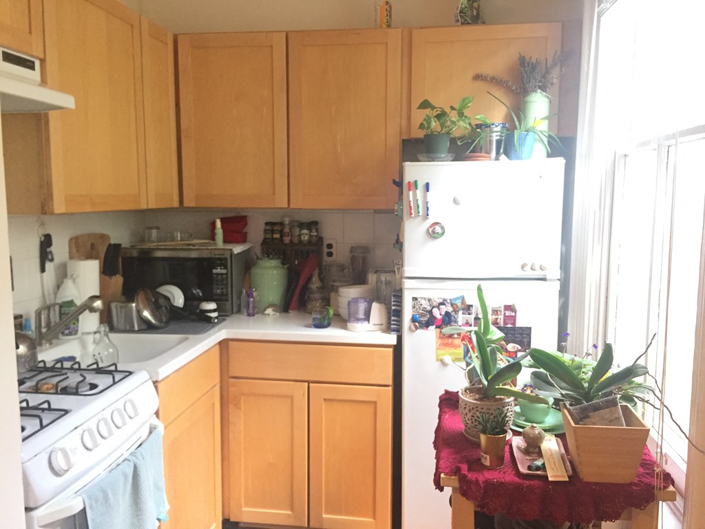 a kitchen with wooden cabinets and a white refrigerator