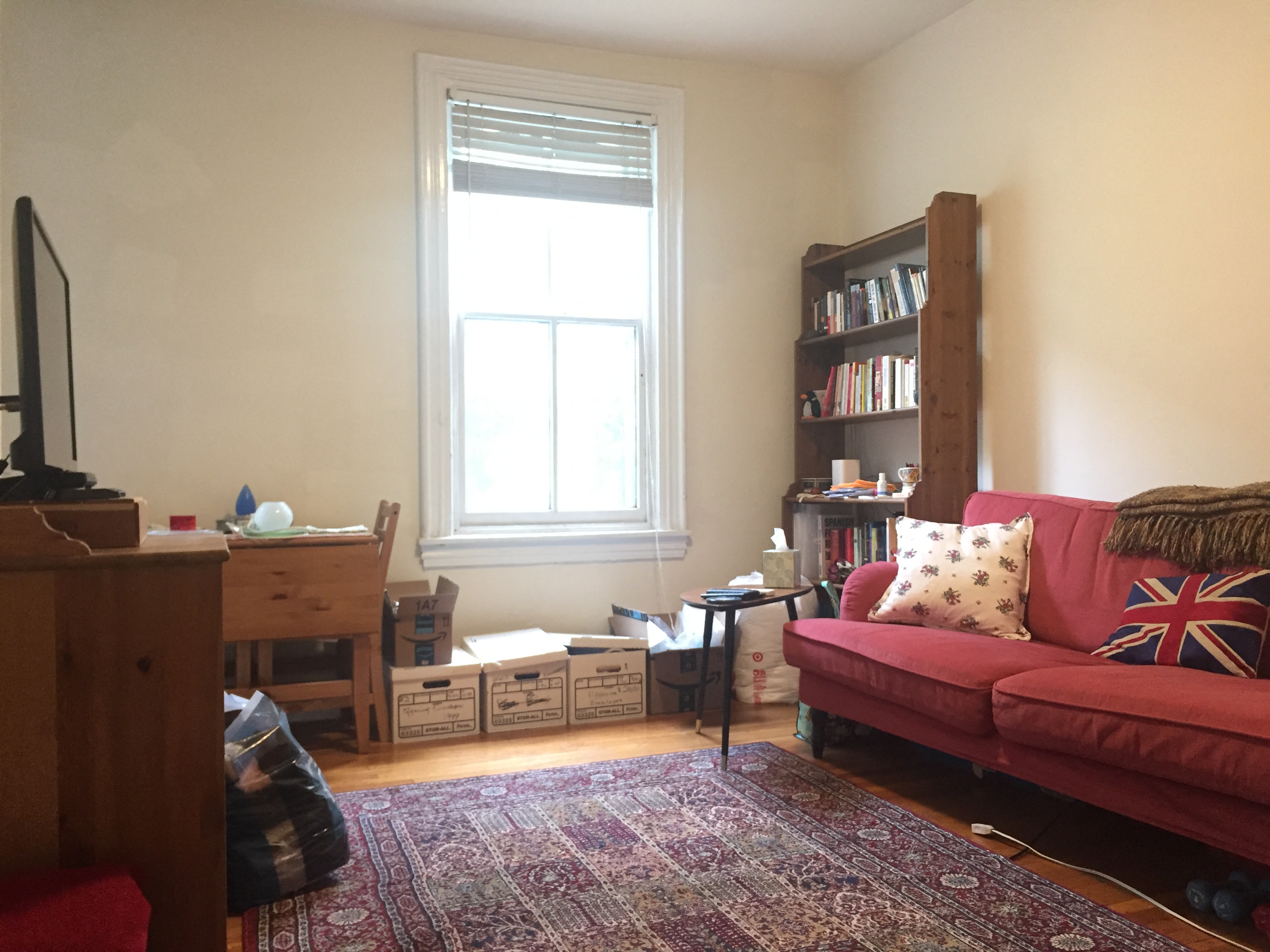 a living room with a red couch and a window