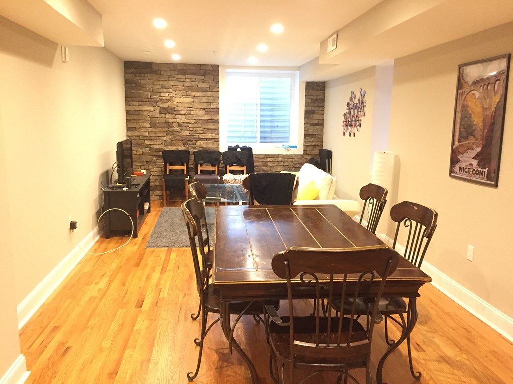 a dining room with a table and chairs and a stone wall
