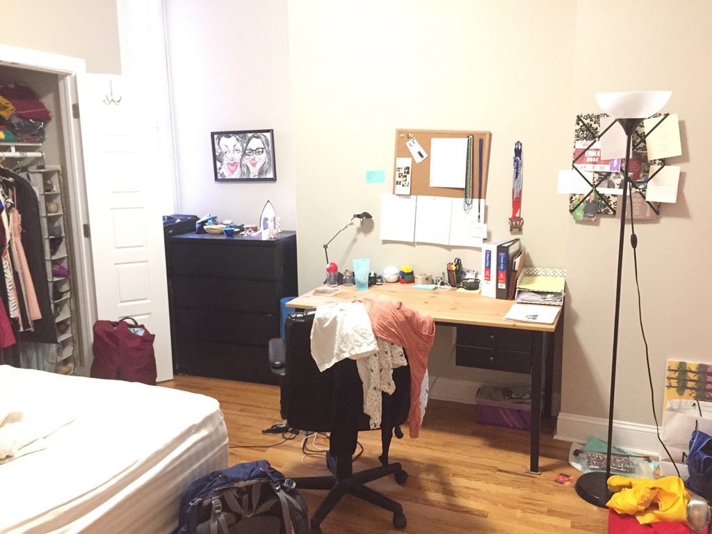 a bedroom with a desk and a bed and a closet