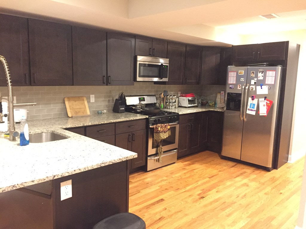 a kitchen with wooden floors and stainless steel appliances