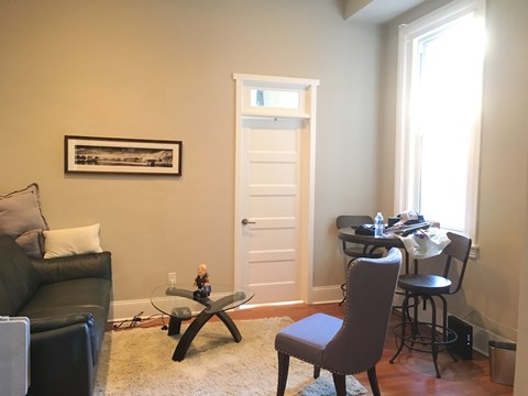 a living room with a desk and a door with a window