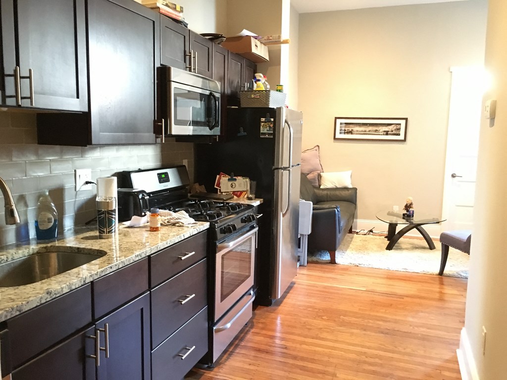 a kitchen with black cabinets and stainless steel appliances