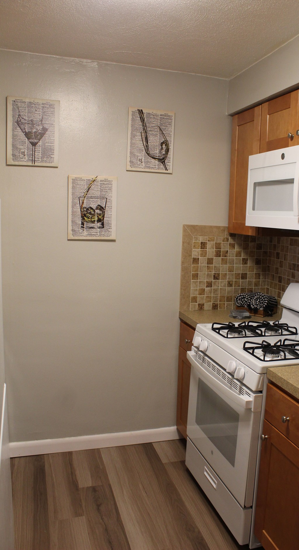 A kitchen with a white stove and cabinets.