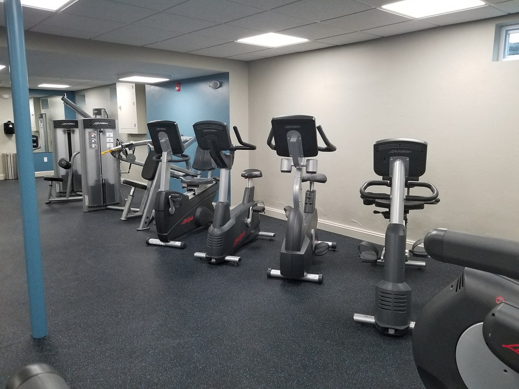 a gym with various exercise equipment on the floor