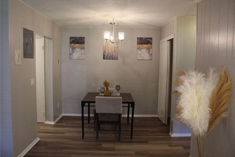 A dining room with a wooden table and chairs.