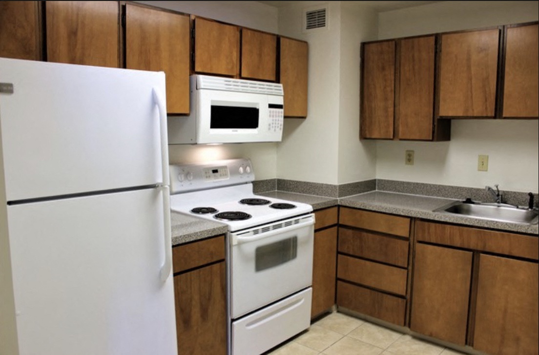a kitchen with white appliances and wooden cabinets