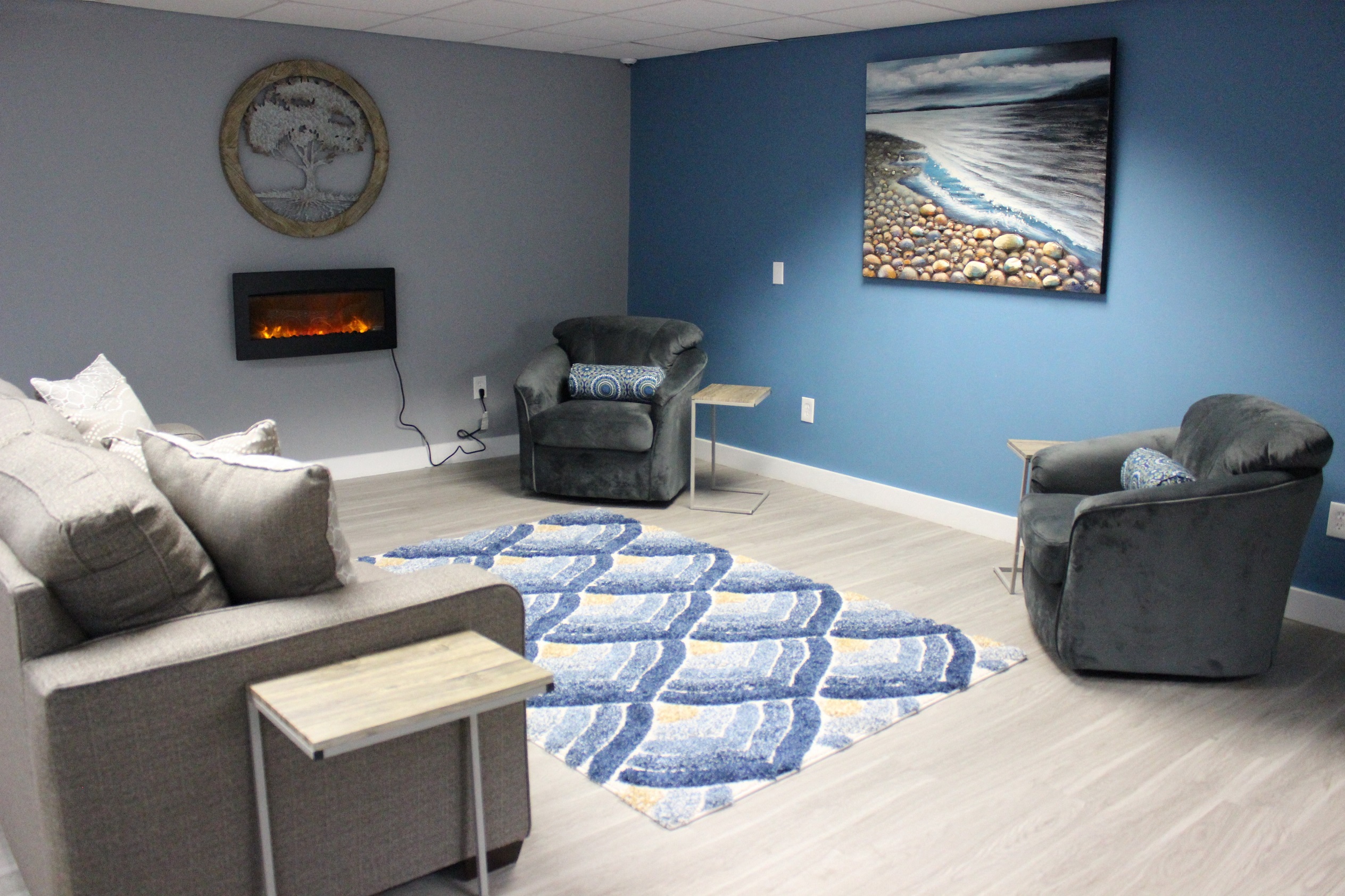 a living room with couches and a rug and a fireplace