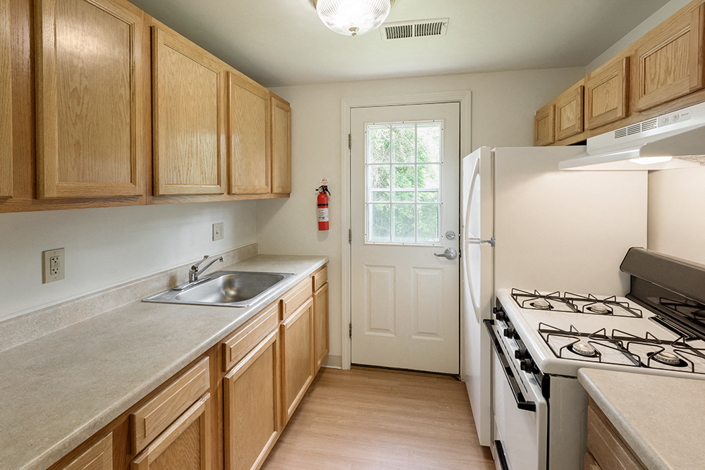 a kitchen with wooden cabinets and a stove and a sink
