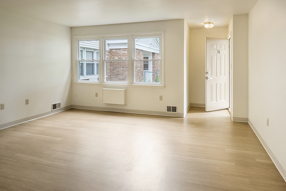 the living room and dining room of an empty apartment