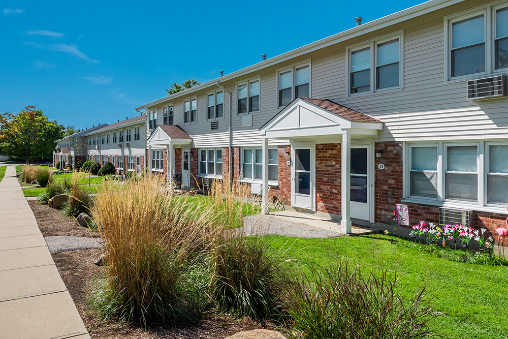 a row of townhomes with lawns in front of them