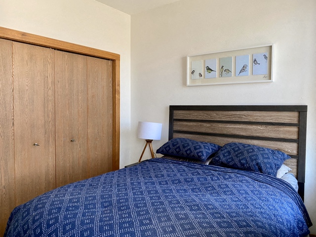 a bedroom with a bed with a blue comforter