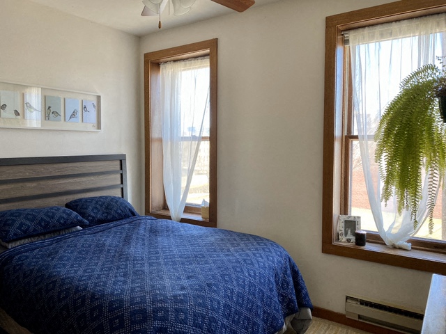 a bedroom with a bed and two windows